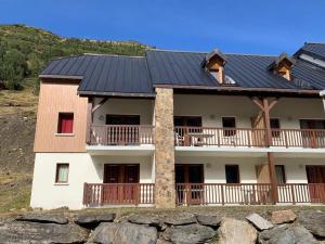 une maison avec des panneaux solaires sur son toit dans l'établissement Appartement 2 chambres en duplex à La Mongie, à La Mongie
