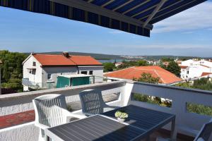 einen Balkon mit einem Tisch und 2 Stühlen sowie Aussicht in der Unterkunft Apartment Vitezic in Punat