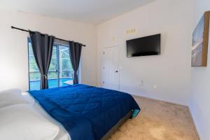 a bedroom with a bed and a tv on the wall at Home in davenport Cheerful 4-bedroom with pool in Davenport