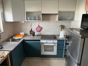 a kitchen with blue cabinets and a stove and a sink at Apartment Vitezic in Punat
