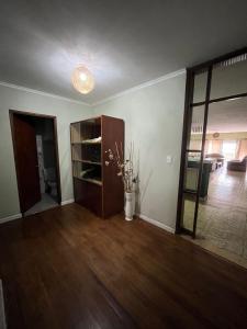 una sala de estar vacía con suelo de madera y puerta en Relax V, en Paysandú