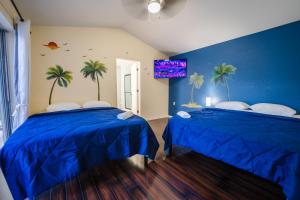 two beds in a room with palm trees on the wall at Home in davenport Cheerful 4-bedroom with pool in Davenport