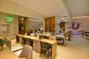 a restaurant with tables and chairs in a room at The Houghton Hotel, Spa, Wellness & Golf in Johannesburg