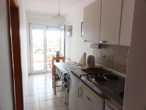 a kitchen with a table and a stove top oven at Villa Tina in Rogoznica