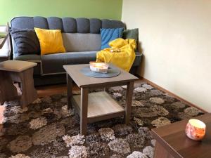 ein Wohnzimmer mit Sofa und Tisch in der Unterkunft Apartman TULANIE 58 Kamzik Donovaly 2 IZBOVY Mezonet Deluxe parkovanie v podzemnej garáži ZDARMA in Donovaly + 43 Fotos
