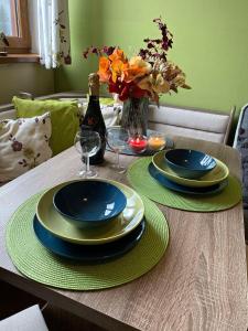 einen Tisch mit 2 Tellern und eine Flasche Wein in der Unterkunft Apartman TULANIE 58 Kamzik Donovaly 2 IZBOVY Mezonet Deluxe parkovanie v podzemnej garáži ZDARMA in Donovaly