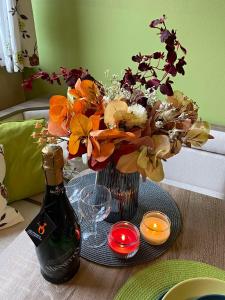 ein Tisch mit einer Flasche Wein und einer Vase mit Blumen in der Unterkunft Apartman TULANIE 58 Kamzik Donovaly 2 IZBOVY Mezonet Deluxe parkovanie v podzemnej garáži ZDARMA in Donovaly