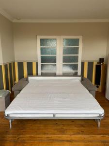 a large white bed in a room with a window at Ferienwohnung Hamburg - Kirchwerder in Hamburg