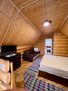 a bedroom with a bed and a couch in a room at Садиба BETWEEN MOUNTAINS in Mizhhirya