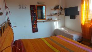 ポルト・エルコレにあるMare e Montiのベッドルーム1室(ベッド2台、窓、テレビ付)