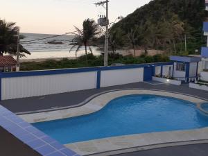 a swimming pool with a view of the beach at COBERTURA Duplex com Visao do Mar, Village das ondas in Piúma