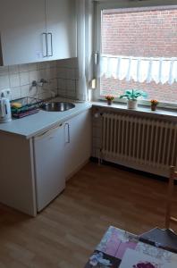 una cucina con lavandino e finestra di Ferienwohnung Elfriede a Papenburg