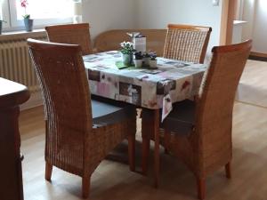 un tavolo da pranzo con sedie e una trapunta sopra di Ferienwohnung Elfriede a Papenburg