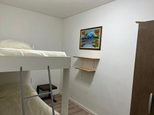 RELAX II في بايساندو: غرفة نوم مع سرير بطابقين وطاولة وصورة