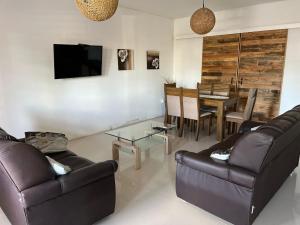 una sala de estar con 2 sofás de cuero y una mesa. en RELAX II, en Paysandú