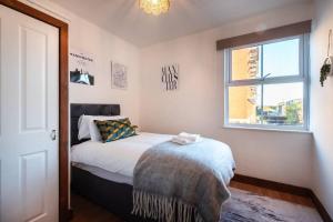 a bedroom with a bed and a window at Highland - 2 Bedroom Flat with Parking in Southampton