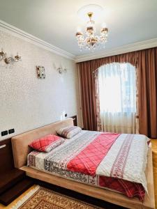 a bedroom with a large bed with a chandelier at Superb Central Location! Spacious and Comfortable 1 Bedroom + Jacuzzi, Next To Northern Avenue in Yerevan