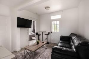 - un salon avec un canapé en cuir noir et une table dans l'établissement 2 bedroom apartment - 1005, à Montréal