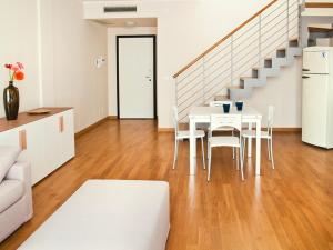 a white table and chairs in a room with a staircase at Studio Apartment in Catania