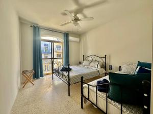 um quarto com uma cama e uma ventoinha de tecto em Seaside Urban Edge Suites- w/3BR em St. Paul's Bay