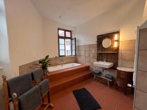 ein großes Bad mit einer Badewanne und einem Waschbecken in der Unterkunft Ferienwohnung Unterm Schloß in Neustadt an der Weinstraße