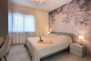 a bedroom with a bed with a tray with flowers on it at Vila Eia in Pula