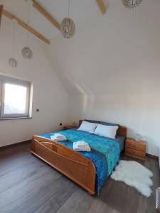1 dormitorio con 1 cama grande y edredón azul en Ob Potoku, 