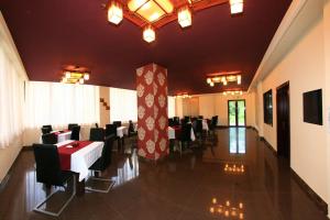 a dining hall with tables and chairs in a restaurant at Pensiunea Sun-Reno in Băile Herculane