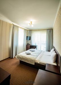 um quarto com uma cama grande e uma janela em Kasimir Resort Hotel & SPA em Bukovel