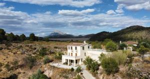 韋斯卡爾的住宿－Vivienda Rural Embalse San Clemente，享有高山房屋的空中景致