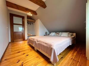 a bedroom with a bed and a wooden floor at Chata Sikorki 