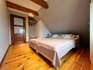 um quarto com uma cama e piso em madeira em Chata Sikorki 