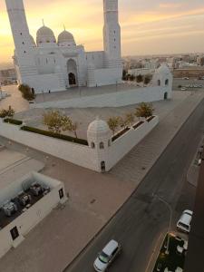 een groot wit gebouw met een weg ervoor bij Hill Top Muscat in Muscat