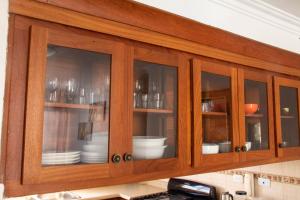 a wooden cabinet with glass doors with dishes in it at Apartamento en Pueblo Bavaro in Punta Cana