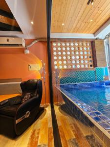 a swimming pool in a room with a bed next to it at 覓思旅Miss inn in Hengchun South Gate
