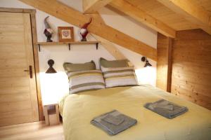 a bedroom with a bed with two towels on it at Chalet La Trafolée in Manigod