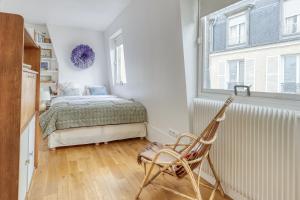 a bedroom with a bed and a window and a chair at Charming Designed Loft - Latin Quarter - Paris 05 in Paris
