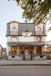 a large white building with aigil on it at GANZ HOTEL in Ivano-Frankivsʼk