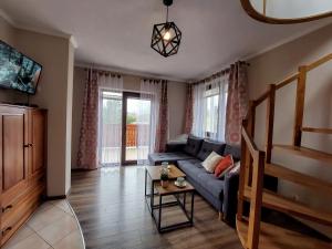 スロモフツェ・ビジネにあるWilla Przekop - apartamentyのソファとテーブルのあるリビングルーム