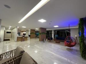a lobby of a building with a couch and chairs at Recanto do Bosque FLAT 205 in Caldas Novas