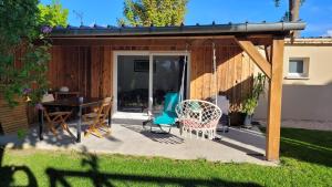 a house with a patio with a table and chairs at Cabanon Mairyon in Mairy-sur-Marne