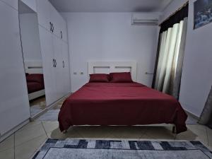 a bedroom with a large bed with a red blanket at Siar Apartment in Tirana