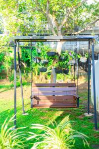 eine Schaukel mit Topfpflanzen in einem Garten in der Unterkunft Villa Green Space in Matara