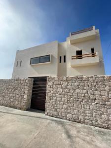 a building with a stone wall and a garage at Loued Surf Lodge in Imsouane