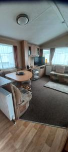 a living room with a table and a couch at Caravan 76 snowdon summit 016 in Talybont