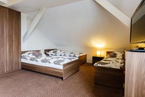 two beds in a room with a tv at Sleep In Łomża in Łomża