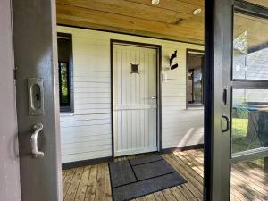 une porte d'entrée d'une maison avec une terrasse couverte dans l'établissement Le chalet du lac, à Robertville