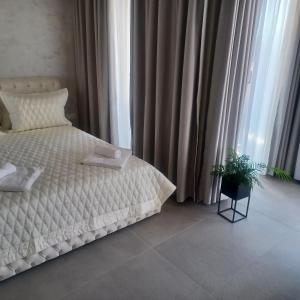 a bedroom with a white bed and a potted plant at Romantic Holiday Studio in St. St. Constantine and Helena