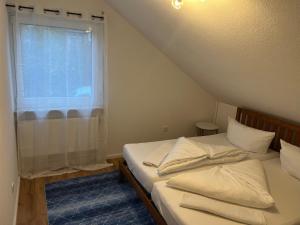 a bedroom with a bed with white pillows and a window at Ferienwohnung Alkapa in Hilzingen