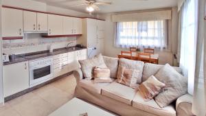 a living room with a couch and a kitchen at Apartamento con wifi en casco histórico Betanzos in Betanzos